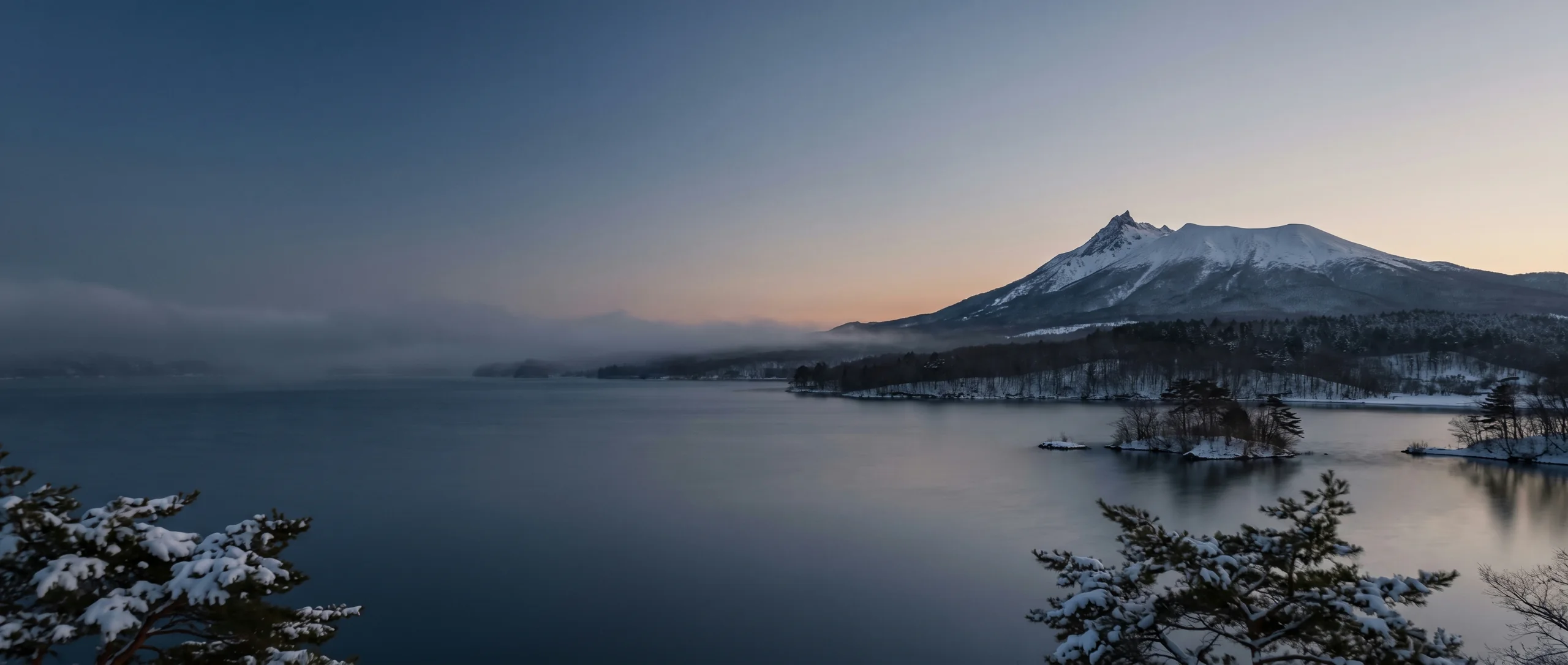 Lake Onuma at winter dusk beneath Mount Komagatake